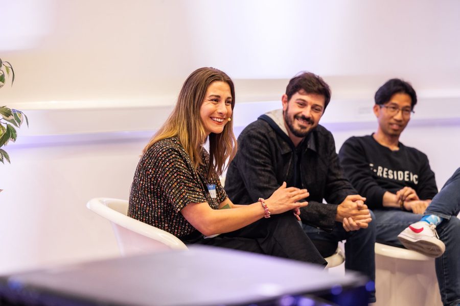 Milly hosting a fireside conversation with a guest, both laughing