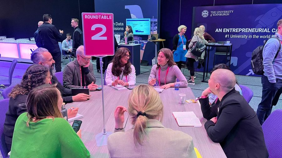 Milly running a roundtable session with participants around a table